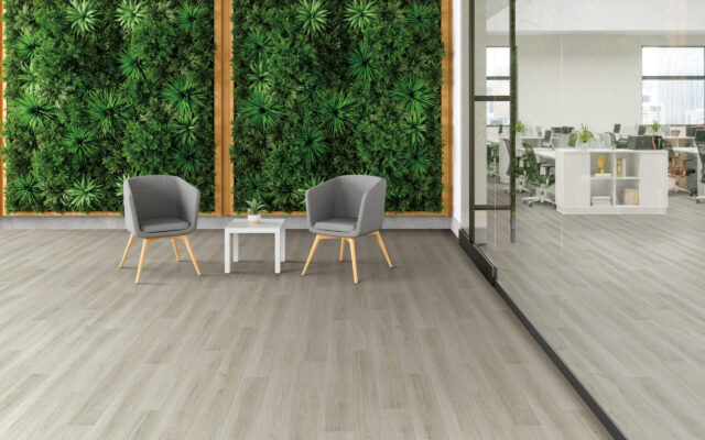 Waiting Area In Green Office With Armchairs, Coffee Table And Vertical Garden.